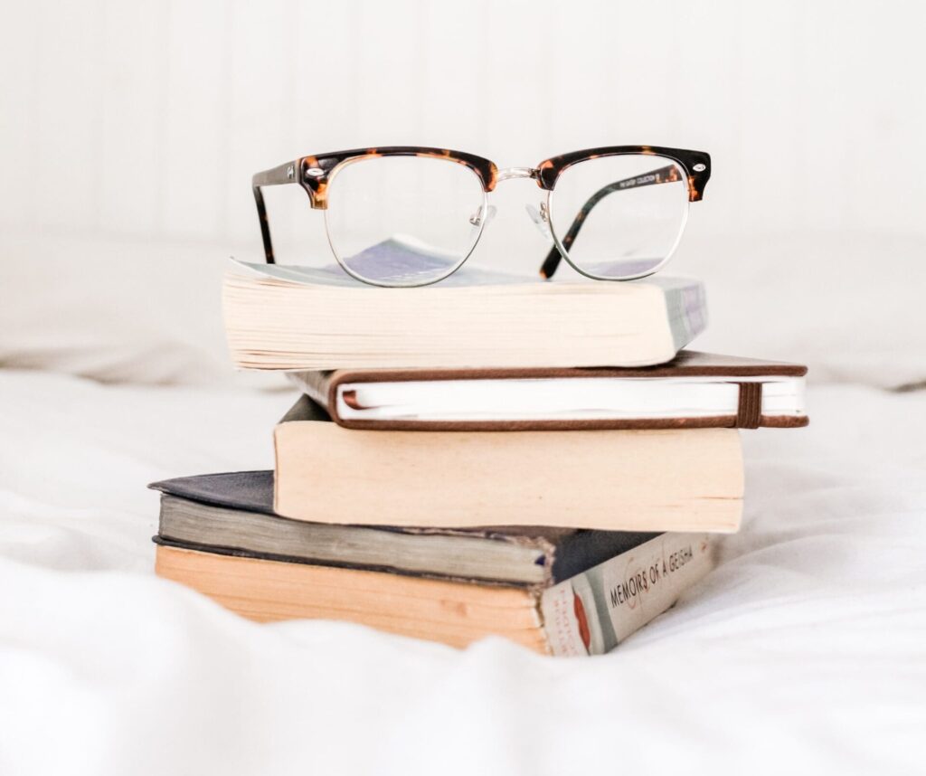 Pile of books with glasses on top.